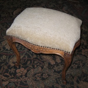 A clean new cover and hobnails update this carved ottoman