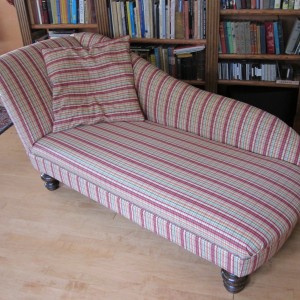 A cheerful plaid and a big floppy pillow completely change the character of this piece. Note that the tuft and button style has also been changed to a smooth, solid construction