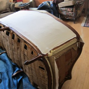 A layer of protective muslin is laid over the burlap strapping